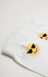 Medias blancas con puño acanalado y diseño de emoji con gafas de sol.