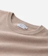 Suéter de punto color gris, con cuello redondo, manga larga y textura maquinetada.