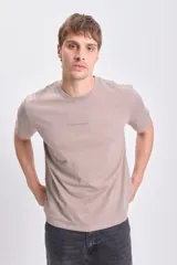 Remera color visón de manga corta con cuello redondo y estampa frontal con la frase "Take a Chance".