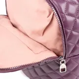 Mochila color lila de cuero sintético acolchado con diseño de rombos. Tiene acceso con cierre, dos compartimentos, un bolsillo interno con cierre y dos bolsillos internos abiertos. Las correas son regulables y los herrajes son plateados.