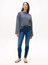 Jean de mujer de tejido denim rígido, color azul medio con efecto desteñido en muslos y rodillas. Presenta un corte de pierna ancha y talle alto, con cierre de cremallera y botón, y estilo de cinco bolsillos.