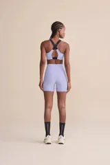 Short deportivo de tiro alto color lila, con tecnología de compresión, protección solar UV 50+, forro estratégico para evitar transparencias, dos bolsillos laterales sin costuras visibles y barra con gripper para un ajuste seguro.