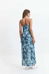 Vestido largo con estampado tie-dye en tonos azules y blancos, breteles finos regulables y espalda con tiras entrecruzadas. Tiene escote en “V” y tajos laterales.