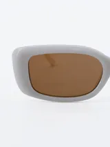 Lentes de sol rectangulares color crema con cristales marrones.
