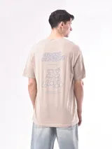 Remera color beige con estampado pequeño en el frente.
