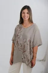 Blusa color visón con estampado de hojas en tonos marrones, de corte holgado y mangas cortas.
