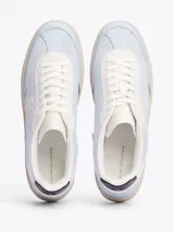 Zapatillas Tommy Hilfiger de cuero sintético color celeste con detalles en blanco y suela color crema. Presentan el logo de la marca bordado en el lateral y detalles distintivos en el talón.
