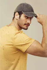 Remera celeste con estampado de figuras geométricas en tonos naranja y verde.