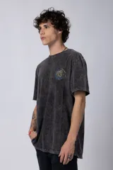 Remera de hombre color gris oscuro con efecto gastado (snow wash), corte semi-oversize y un pequeño estampado circular en el pecho que simula una obra de arte.
