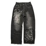 Pantalón de jean negro con efecto lavado, corte amplio, tiro bajo y estampado serigrafiado en blanco.