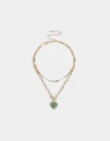 Collar corto doble con cadena dorada de eslabones rectangulares y cadena de mostacillas de colores con dije de corazón dorado y dije de piedra verde en forma de corazón.