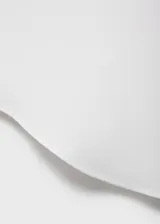 Camisa blanca sin mangas con cuello camisero y cierre frontal con botones.