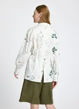 Camisa de manga larga con estampado floral y de texto, con cuello clásico, cierre frontal con botones y lazo ajustable en la cintura.