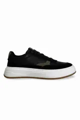 Zapatillas urbanas negras con detalles en gris y suela blanca con base marrón.