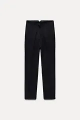 Pantalón largo negro con finas rayas verticales blancas, de tiro alto y corte recto.