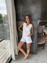 Chaleco sastrero blanco con pespuntes en contratono, escote en V y cierre frontal con botones.