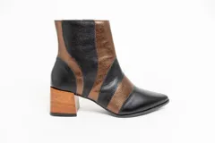 Botas cortas de cuero negro y bronce, con punta fina, cierre lateral y taco de madera.