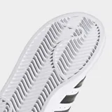 Zapatillas Adidas Superstar blancas con las tres tiras laterales en negro y puntera de goma.