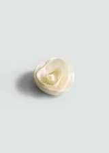 Broche con forma de rosa color crema, confeccionado en tejido satinado.