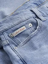 Pantalón de jean celeste de corte mom, tiro alto, cinco bolsillos y cierre con cremallera.