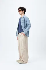 Pantalón cargo color beige, de corte recto y holgado, con cintura elástica y bolsillos laterales con solapa.