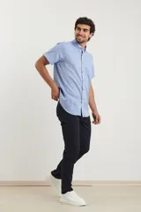Camisa celeste de manga corta con cuello abotonado y bolsillo en el pecho.