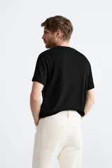 Jersey de punto color marrón oscuro, de corte relajado (relaxed fit), con cuello redondo y manga corta.