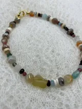 Collar corto de cuentas de piedras semipreciosas de diferentes colores y formas, con cierre de gancho dorado.