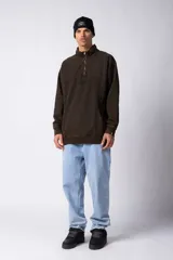 Buzo negro de frisa 100% algodón con medio cierre y bordado al tono. Tiene un lavado snow que le da un look gastado.