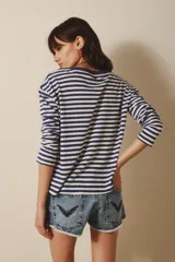 Remera de manga larga confeccionada en algodón a rayas horizontales azul marino y blanco. Tiene un pequeño bordado de corazón rojo en el frente y cuello redondo.