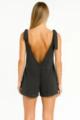 Mono corto negro con breteles anchos con nudos en los hombros y bolsillos delanteros.