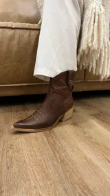 Botas texanas cortas de cuero color marrón chocolate, con punta fina, caña baja y taco de madera.