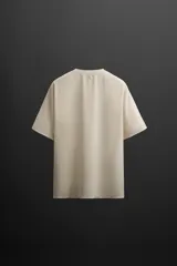 Camiseta deportiva marrón de tejido técnico, ligero y elástico con perforaciones. Cuello redondo, manga corta y logo estampado.