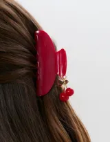 Broche para el pelo color rojo con forma de pinza y detalle de cerezas colgantes.