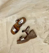 Sandalias con plataforma de gamuza color marrón y tiras de cuero sintético plateado.