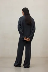 Sweater de tejido de punto color gris oscuro, con escote en V profundo y mangas largas amplias. El diseño es holgado y presenta aberturas laterales.