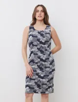 Vestido tejido sin mangas, con estampado floral en tonos azul, gris y blanco. Tiene cuello redondo y abertura central en la espalda con cierre invisible.