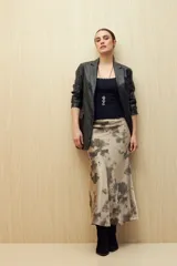 Falda midi de satén color beige con estampado abstracto en tonos grises.