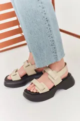 Sandalias con plataforma color beige, con tiras anchas ajustables con velcro y suela track color negro.