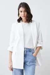 Blazer color crudo de corte recto, con cuello solapa, mangas 3/4 con botón y bolsillos frontales.