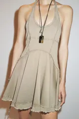 Vestido corto color beige con cuello halter y falda con godets.