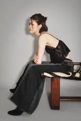 Jean de corte wide leg en color negro, con diseño de paneles laterales en un tono ligeramente más oscuro. Presenta cintura media y cierre frontal con botón y cremallera.