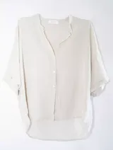 Camisa color crema, de manga corta y corte amplio.