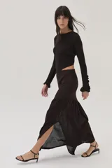 Top tejido en lurex y viscosa, color marrón oscuro, de manga larga, con espalda cruzada y mini volados en los puños.