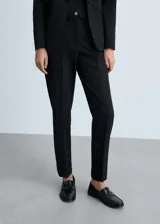 Pantalón de vestir negro con corte recto y ruedo con dobladillo.