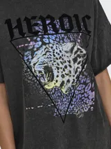 Camiseta negra con estampado de leopardo dentro de un triángulo y la palabra 'HEROIC' en la parte superior. Corte holgado y mangas cortas.