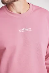 Buzo rosado de corte holgado con cuello redondo y puños y cintura acanalados.