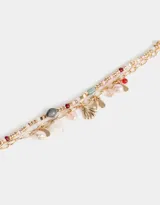 Pulsera flexible dorada de doble cadena con cuentas de colores y dijes de caracol y metal.