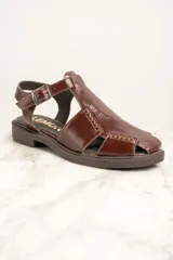 Sandalias de cuero marrón con diseño de tiras cruzadas y hebilla lateral.