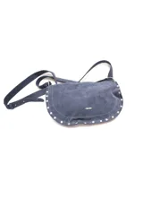 Bandolera azul de gamuza con forma curva, correa ajustable y detalles de tachas plateadas en el borde inferior.
